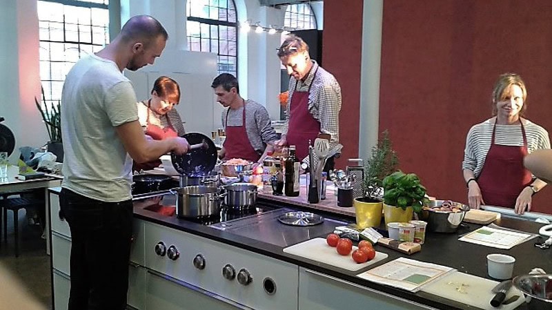 Teamkochen in Dresden - Männer und Frauen am Herd in einer Kochschule in Dresden