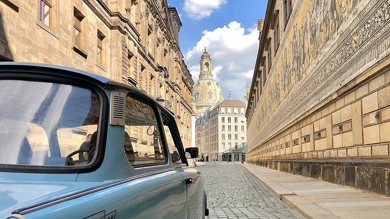 links ein Trabant, rechts der Fürstenzug in Dresden