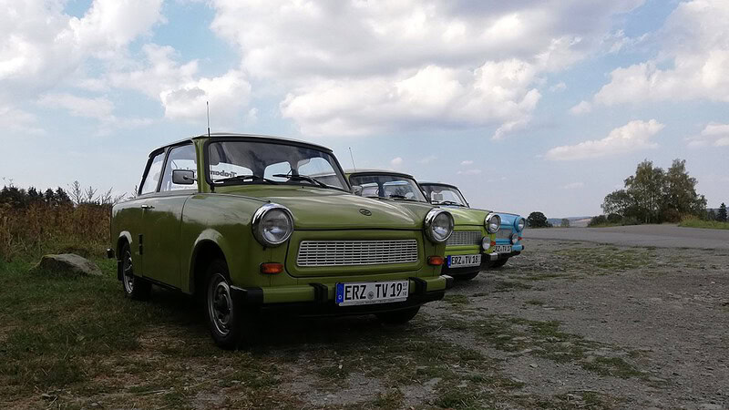 Drei Trabant stehen nebeneinander im Erzgebirge in den Farben Dunkelgrün, Grün und Blau