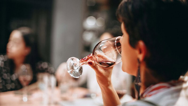 Eine Frau trinkt Rotwein aus einem Weinglas