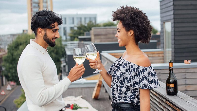 Ein Paar feiert und trinkt Weißwein zusammen