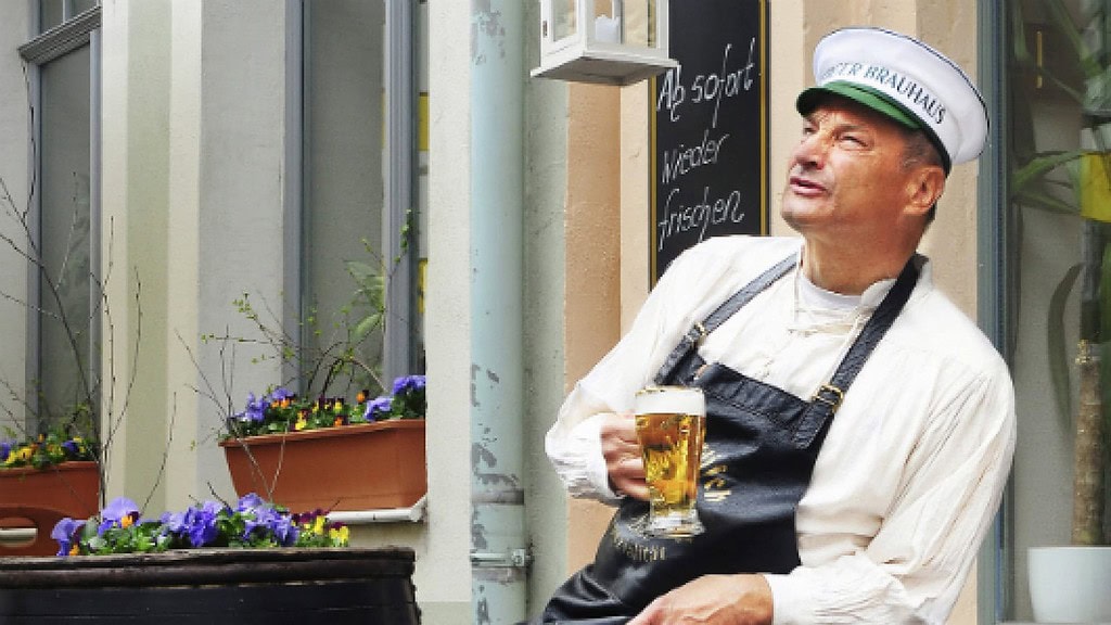 Braumeister mit Bierglas in der Hand beim Bierrundgang Meißen