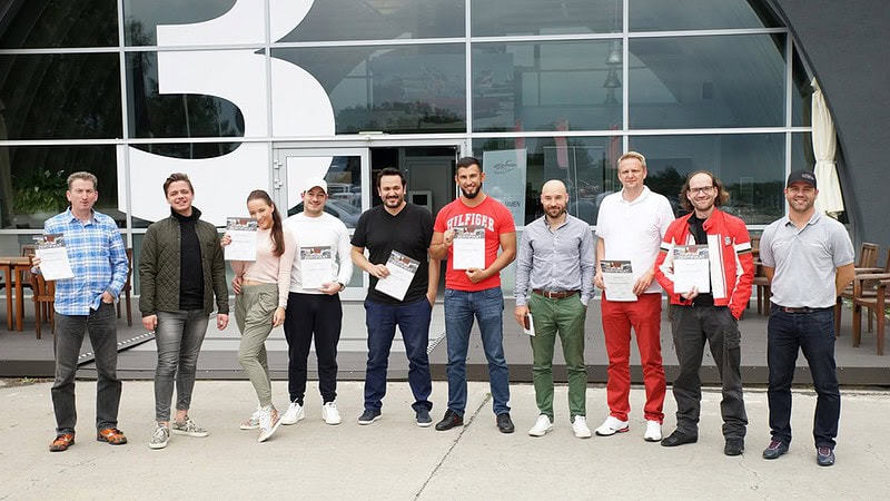 Teilnehmer mit Zertifikaten beim Sportfahrertraining auf dem Lausitzring