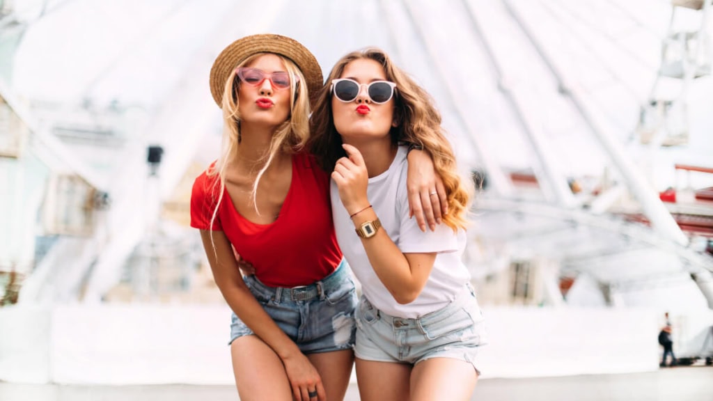 zwei Freundinnen posieren zusammen bei einem Fotoshooting im Freien