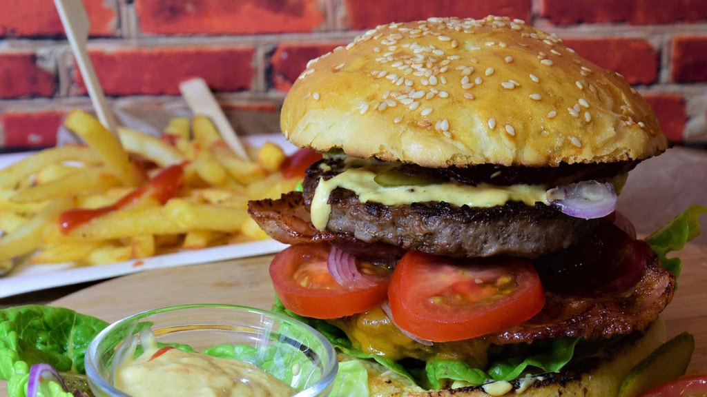 Burger mit Patties und im Hintergrund Pommes