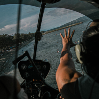 Zwei Personen an Bord eines kleinen Flugzeugs fliegen über die Insel