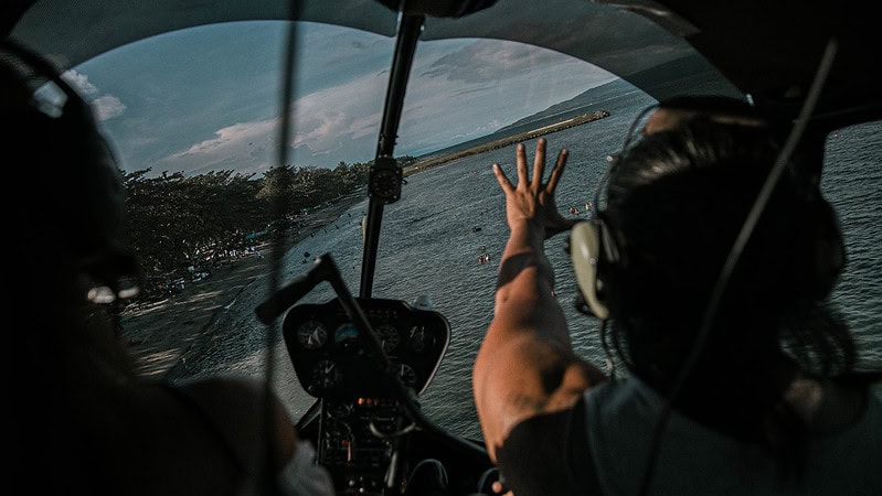 Zwei Personen an Bord eines kleinen Flugzeugs fliegen über die Insel