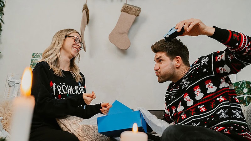 Mit dem Trabi aus der Geschenkbox wir gespielt- Paar sitzt auf dem Sofa zu Weihnachten