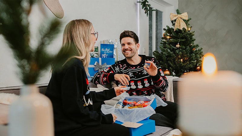 Geschenkbox wird ausgepackt, Schokolade wird hochgehalten