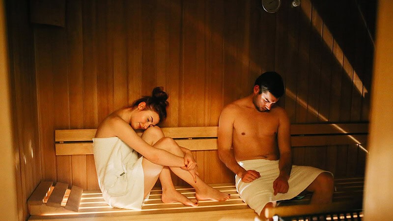 Frau und Mann sitzen in der Sauna