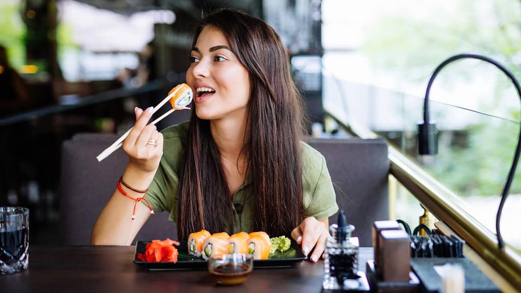 Eine Frau genießt ihr Sushi in einem Restaurant