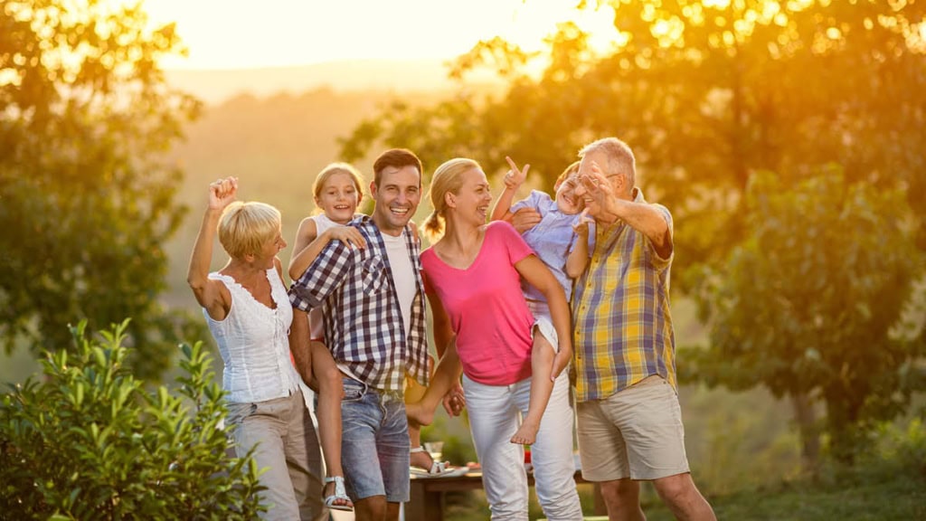 Eine Familie steht in der Natur und freut sich sehr.