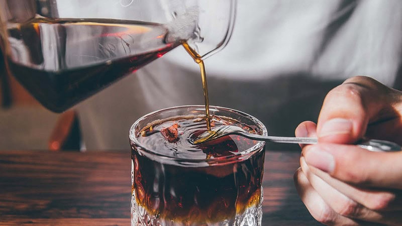 Kaffee wird in ein Glas eingegossen.