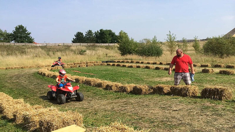 Ein Scout betreut zwei Kinder in einem Parours.