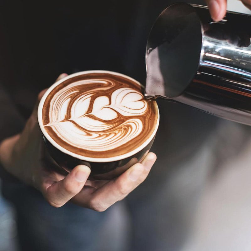 Ein Mann lernt Latte Art bei einem Barista-Workshop