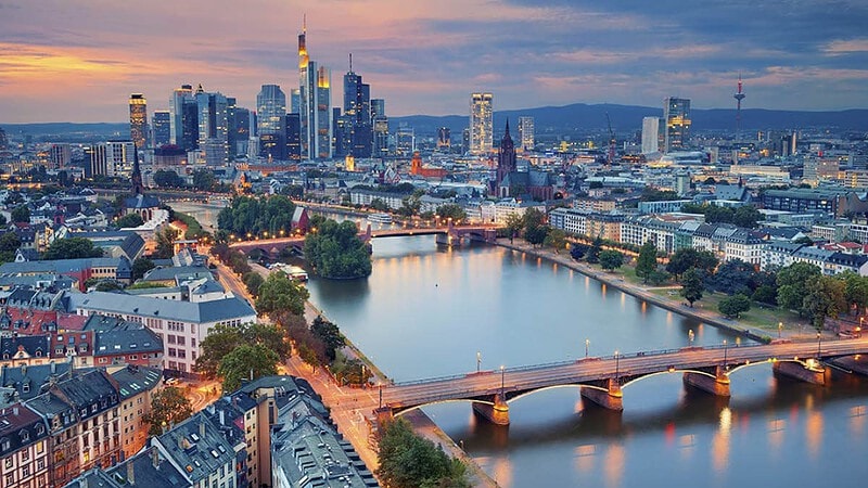 Luftaufnahme von Frankfurt am Main am Abend, Fluss und Brücke im Vordergrund