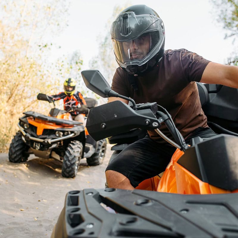 2 Männer fahren Quads auf einer Offroad-Strecke