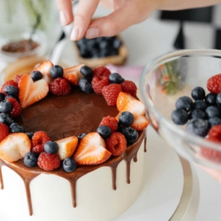 weißer Schokoladenkuchen mit Schokoladensauce und Früchten