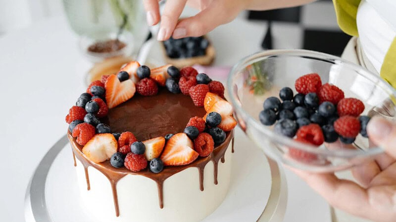 weißer Schokoladenkuchen mit Schokoladensauce und Früchten