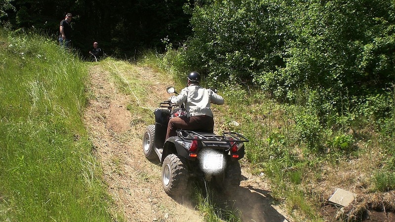 Ein Quadfahrer fährt einen steilen Hang hoch