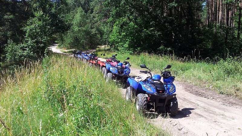 Quads, abgeparkt an einer Wiese am Wald