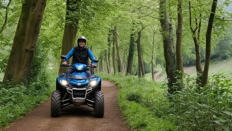 Ein Quadfahrer mit blauem Quad auf Waldweg