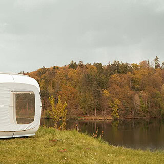 Standort des Sleep Cubes direkt am See. Links der weiße Cube, rechts der See mit Wald