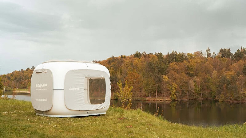 Standort des Sleep Cubes direkt am See. Links der weiße Cube, rechts der See mit Wald