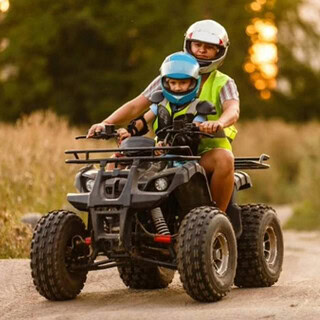 Ein Vater der mit seinem Sohn Quad fährt.